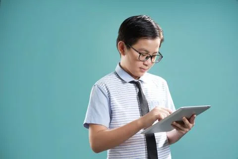 Smart asian boy using digital tablet to learning , isolated on mint green bac Stock Photos