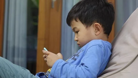 Smart asian kid using smartphone. Child playing game through internet. Stock Footage 158594702