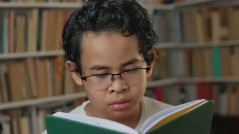 Smart Asian student boy reading a book in library, educational, kid learning  Stock Footage 141964588
