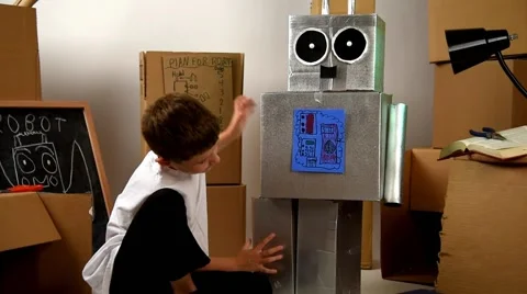 Smart Boy Inventing a Toy Robot out of Boxes Video stock 65448476