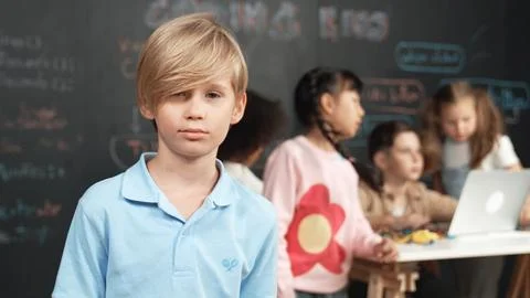 Smart boy looking at camera while diverse friend working at board. Erudition. 스톡 사진