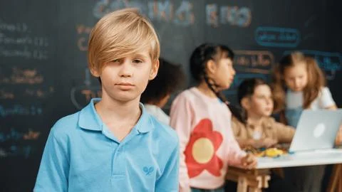 Smart boy looking at camera while diverse friend working at board. Erudition. 스톡 사진