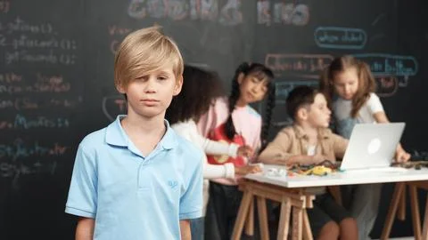 Smart boy looking at camera while diverse friend working at board. Erudition. 스톡 사진
