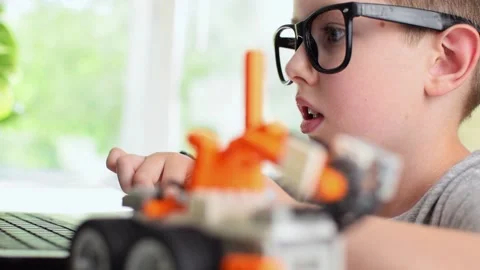 Smart boy programming robot car using laptop. Robotics, STEM education for kids. Stock Footage 196792887
