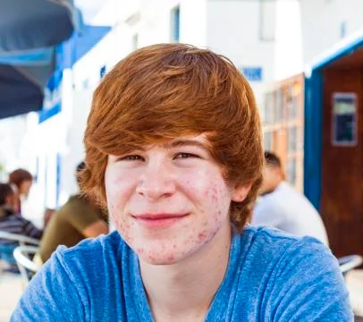 Smart boy in puberty sitting on an outdoor table in the village Foto stock