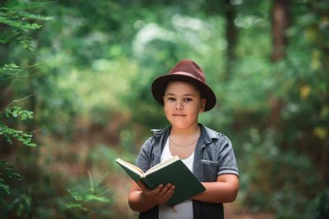 Smart boy reading a book outdoors in nature Foto stock