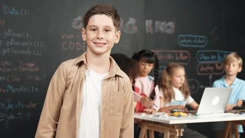Smart boy smiling at camera while diverse friend working at board. Erudition. 스톡 사진