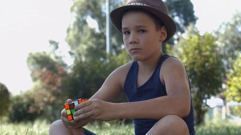 Smart Boy Solving A Rubik's Cube Puzzle.  Boy Tries To Finish Solving Stock Footage 116047120