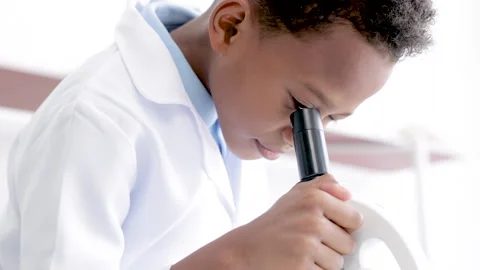 Smart boy student wearing lab coat using microscope equipment and tube anal.. Stock-Footage 243556287