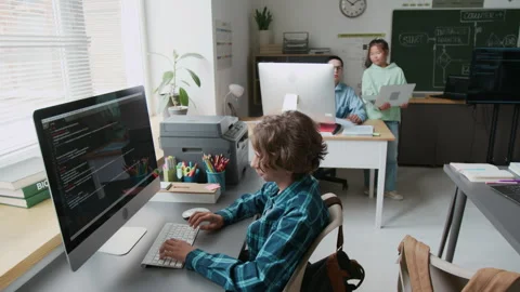 Smart Boy Typing Code on Computer During Programming Lesson in School Stock Footage 317642149