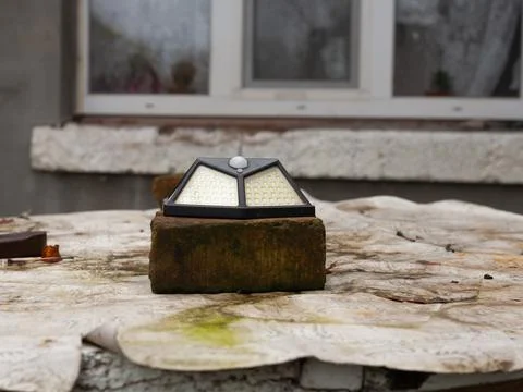 Smart bright sensor light solar rests on a brick Stock Photos