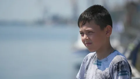 Smart brunet boy standing and looking at boundless Dnipro in summer in slo-mo Stock-Footage 113579407