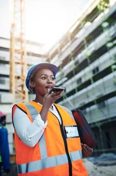 A smart building contractor uses smart tools. a young woman using a smartphone Fotos de archivo