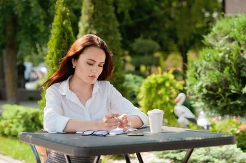 Smart business writes in a notepad during a coffee break Stock Photos