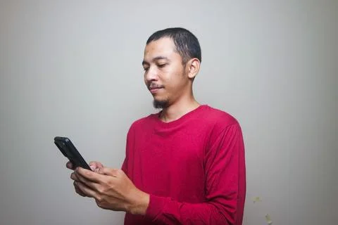 Smart casual asian man using smartphone in studio background Stock Photos