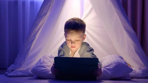 Smart child boy doing tasks in educational program website app in tablet. Stock Photos