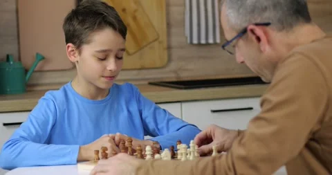Smart child makes a chess move and smiles. Boy looks at board with excitement Stock Footage 330710418