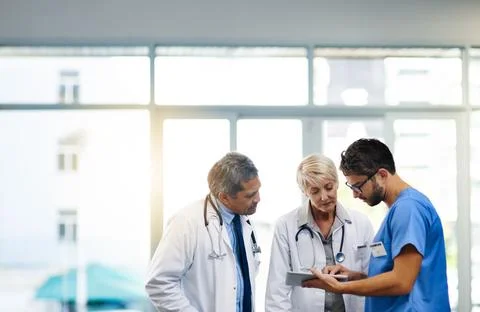 Smart doctors use smart apps. Shot of a team of doctors using a digital tablet Stock Photos