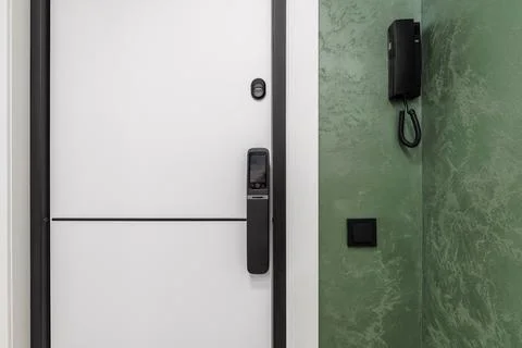 Smart door lock with video intercom on white apartment door Stock Photos