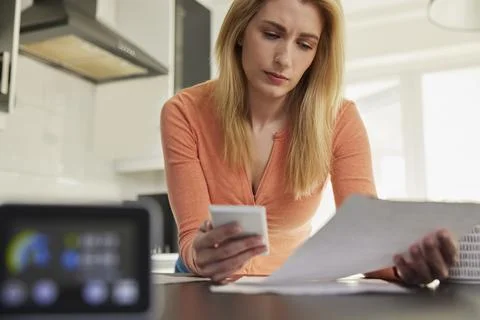 Smart Energy Meter In Kitchen Measuring Electricity And Gas Use With Woman Lo Stock Photos