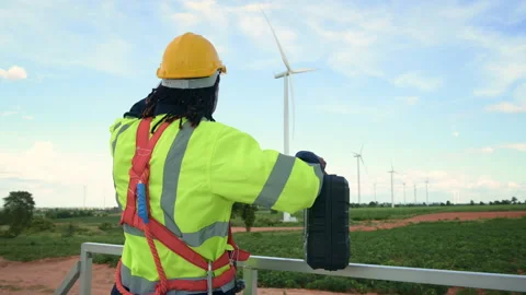 A smart engineer is putting a protective helmet on head at electrical turbi.. Stock Footage 269101028
