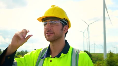 A smart engineer is putting a protective helmet on head at electrical turbi.. Stock Footage 269101081