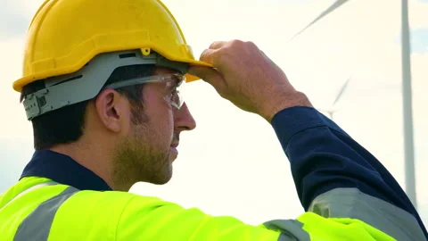 A smart engineer is putting a protective helmet on head at electrical turbi.. Stock Footage 269101301
