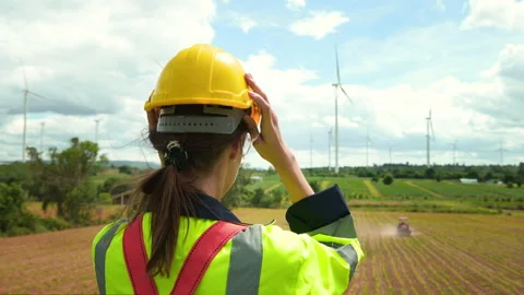 A smart engineer is putting a protective helmet on head at electrical turbi.. Stock Footage 269101375