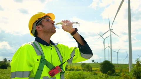 Smart engineer wearing protective helmet drinking water while  working at e.. Stock Footage 269098072