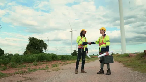 Smart engineers with protective helmet shaking hands at electrical turbines.. Stock Footage 269100183
