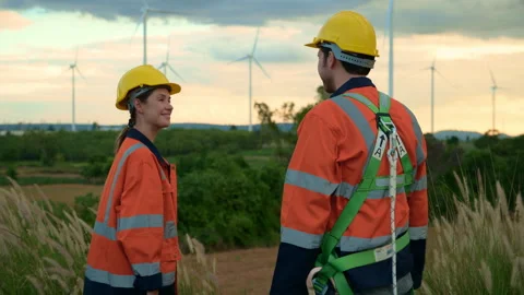Smart engineers with protective helmet shaking hands at electrical turbines.. Stock Footage 269100190