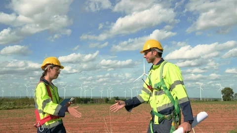 Smart engineers with protective helmet shaking hands at electrical turbines.. Stock Footage 269100351