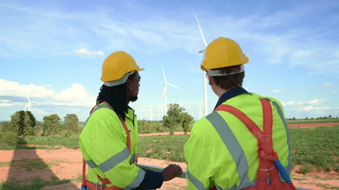Smart engineers with protective helmet shaking hands at electrical turbines.. Stock Footage 269100402