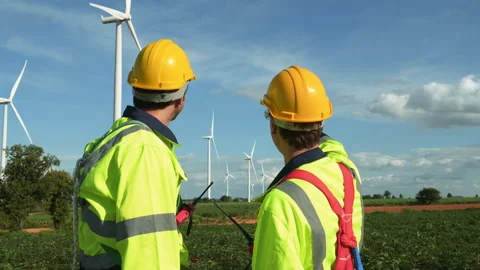 Smart engineers with protective helmet shaking hands at electrical turbines.. Stock Footage 269100435