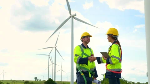 Smart engineers with protective helmet shaking hands at electrical turbines.. Stock Footage 269100600