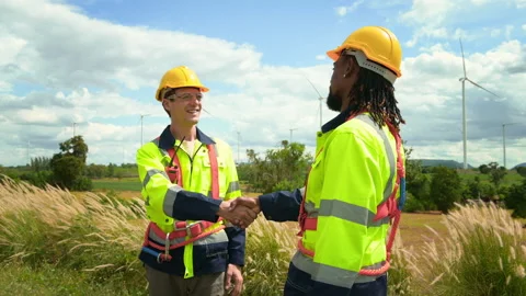 Smart engineers with protective helmet shaking hands at electrical turbines.. Stock Footage 269100614