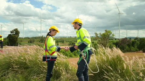 Smart engineers with protective helmet shaking hands at electrical turbines.. Stock Footage 269100710