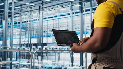 Smart factory engineer designs robotic machines using laptop CAD software Stock Photos