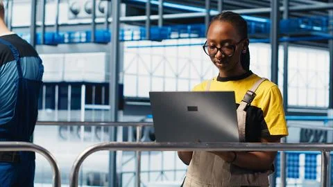 Smart factory engineer oversees operation of robotic arms Stock Photos