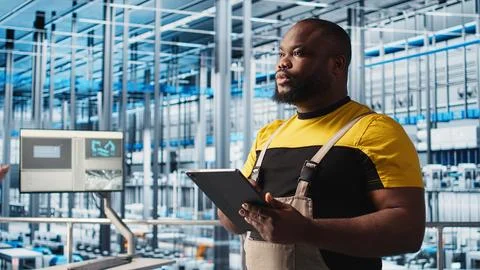 Smart factory engineer oversees operation of robotic arms and assembly lines Stock Photos