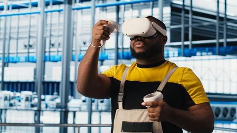 Smart factory engineer using VR headset to oversee operation of robotic arms Stock Photos