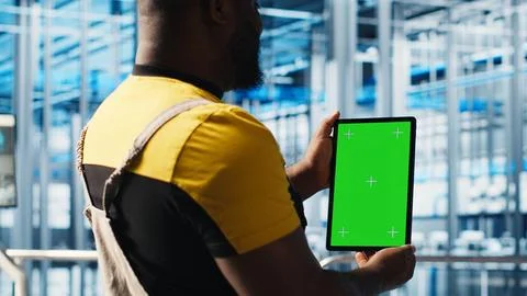 Smart factory expert using green screen tablet to test automated systems Stock Photos