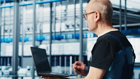 Smart factory expert using laptop software to test automated systems Stock Footage 305492816