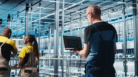 Smart factory expert using laptop software to test automated systems Stock Footage 305515173