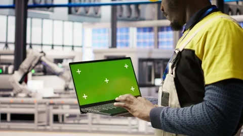 Smart factory mechanic testing automated systems using isolated screen laptop Stock Footage 308718920