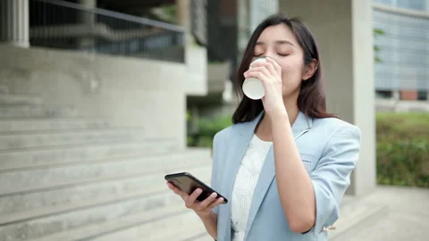 Smart female going with smart phone and coffee cup to office in the morning. Stock Footage 169902151