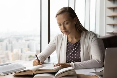 Smart female handwrite study online with books Stock Photos
