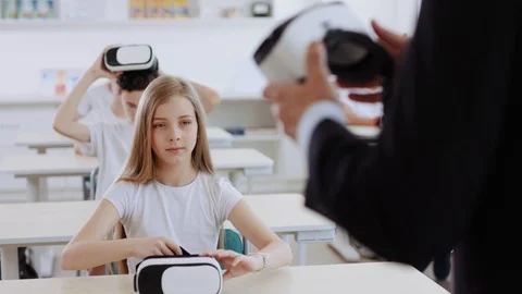 Smart future kids wearing VR headsets by their teacher's command. Exciting Stock Footage 111542792