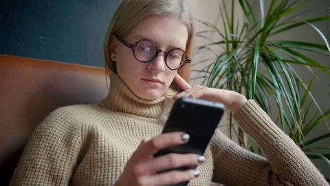 Smart geek girl using mobile phone installing app Strolling and publishing post Stock Footage 103285857