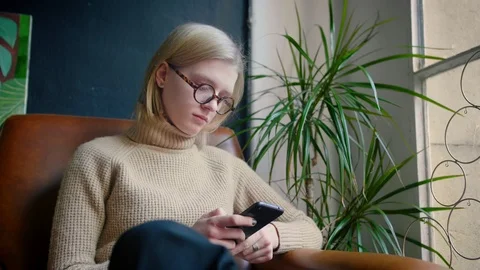 Smart girl with glasses using mobile phone check social network like Instagram Stock Footage 103287063